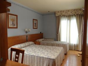 贝纳瓦雷Hotel Casa Carmen的酒店客房设有两张床和窗户。