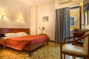 雅典涅斐勒酒店的配有一张床和一把椅子的酒店客房