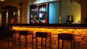 卡图扎克罗鲁Olympios Zeus Hotel的吧台前有四把凳子的酒吧