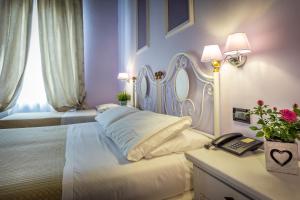佛罗伦萨费鲁奇酒店的卧室配有白色的床和带电话的桌子。