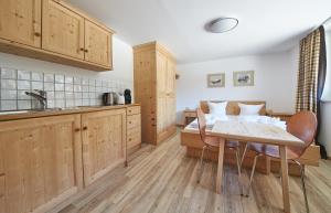 萨尔巴赫Appartement Kohlmais的厨房配有木制橱柜和桌椅