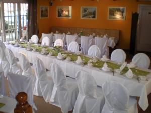 布科伽斯特豪斯涛博尔穆勒酒店的长宴会厅配有白色的桌子和白色的椅子