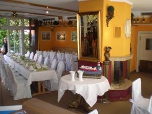 布科伽斯特豪斯涛博尔穆勒酒店的一间设有白色桌子、白色椅子和镜子的客房
