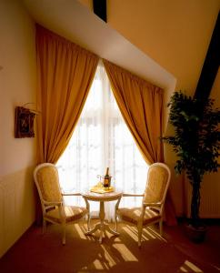 布科伽斯特豪斯涛博尔穆勒酒店的客房设有桌子、两把椅子和窗户。