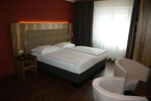 StettenHotel-Restaurant Schweinberger的一间卧室配有一张大床和两把椅子