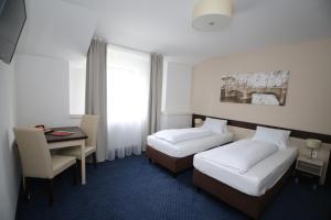 比尔森甘特康体旅馆的酒店客房配有两张床和一张书桌