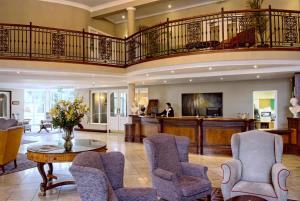 恩尼斯伍德斯托克恩尼斯酒店的客厅设有楼梯和桌椅