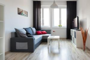 什切青Apartament Wały Chrobrego的客厅配有蓝色的沙发和电视