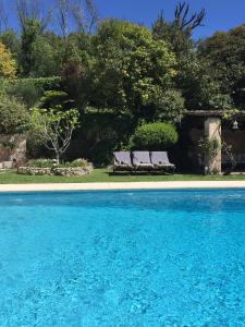 圣保罗-德旺斯圣保罗别墅酒店的游泳池旁的两把长椅