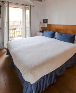 罗马佩蒂娜利乡村住宿加早餐旅馆的卧室配有带蓝色枕头的大型白色床