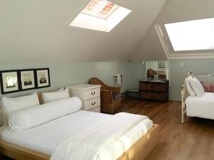 帕罗奥多Cowper Inn的卧室配有一张白色的大床和天窗。