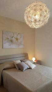 CaltabellottaCasa Sofia的一间卧室配有一张带大吊灯的床