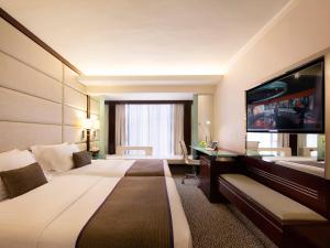香港富豪九龙酒店的一间酒店客房,配有一张大床和一台平面电视