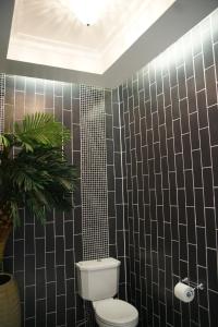 莱城Hotel Morobe的一间带卫生间的浴室和黑色瓷砖墙