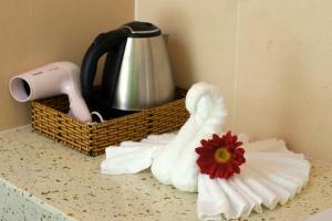 富国金沙滩别墅酒店的一个带毛巾的柜台、茶壶和花