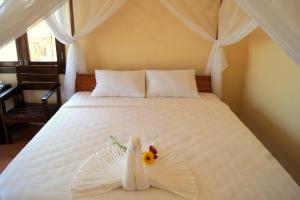 富国金沙滩别墅酒店的卧室配有白色的床,床上有花