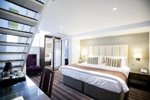 伦敦支柱酒店的一间设有大床和楼梯的酒店客房
