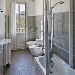 拉文纳M俱乐部德卢克斯住宿加早餐酒店的浴室设有2个卫生间、水槽和浴缸。