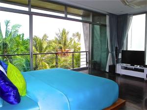 拉威海滩伊娃拉威三卧室私人泳池别墅的带阳台的客房内一张大蓝色的床