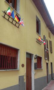 Veleso卡多纳木屋住宿加早餐旅馆的一面有旗帜的黄色建筑