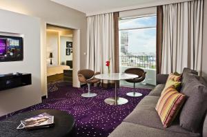 芭堤雅市中心Hard Rock Hotel Pattaya的一间配有沙发、桌子和窗户的酒店客房
