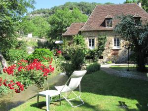 莱塞齐耶德泰阿克Le Moulin De La Beune的坐在房子前面的草上的一个白色椅子