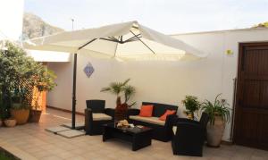 圣维托罗卡波Kimos的庭院配有白色遮阳伞、椅子和桌子
