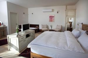 罗什平纳Boutique Hotel Tamarin的卧室配有一张白色大床和电视。
