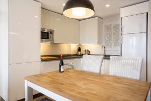 科尔多瓦河上公寓的厨房配有木桌和一瓶葡萄酒