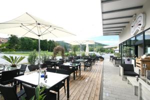 Peggau拉库齐纳酒店及餐厅的室外餐厅设有桌椅和遮阳伞。