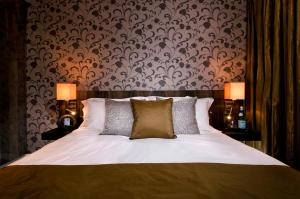 亨顿海德酒店的一间卧室配有一张大床和两盏灯