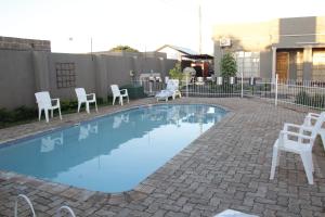 利文斯顿阿散蒂公寓的一个带白色椅子和围栏的小游泳池