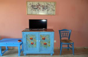 KástronPolytropon Apartments的蓝色的橱柜,配有电视和椅子