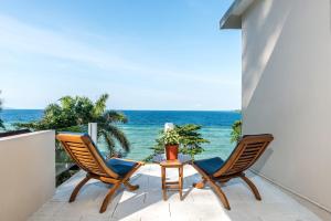布纳肯布纳肯恰恰自然度假酒店的阳台上配有两把椅子和一张桌子,享有海景