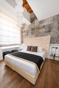 罗马DC Collection Spagna的卧室配有白色大床和砖墙
