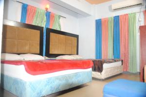 库克斯巴扎Hotel Sea Alif的配有色彩缤纷窗帘的客房内的两张床