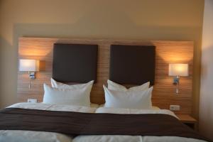 汉堡哈伯格老城酒店的一间卧室配有一张带两个枕头和两个灯的床。
