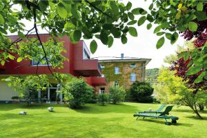 巴特诺因阿尔-阿尔韦勒Hotel Villa Sanct Peter的坐在建筑物前面的草上的一个长凳