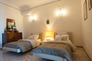 维耶特里马勒伦纳公寓 - 阿马尔菲海岸的一间卧室配有两张床、一个梳妆台和一盏灯。