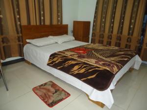 库克斯巴扎Unity Inn的一间卧室配有一张床铺,床上有毯子
