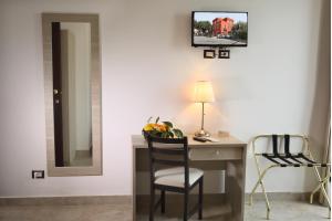 陶尔米纳阿斯托利亚别墅酒店的客房设有带椅子和镜子的书桌