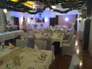 布利斯卡斯特尔Bliestal Hotel的一间设有白色桌椅和圣诞树的餐厅