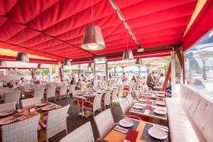 阿尔库迪亚港布瑞滨海旅馆的餐厅拥有红色的天花板和桌椅