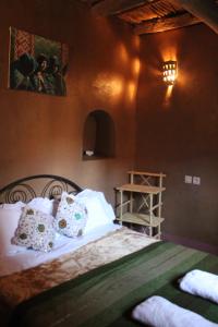 Aït BahaKasbah Maison D’hôte Lalla Zahra的一间卧室配有带白色床单和枕头的床。