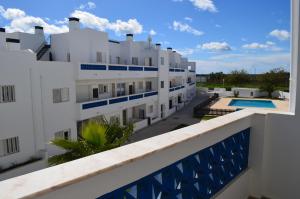 圣卢西亚岛Santa Luzia Apartment的从带游泳池的大楼的阳台上可欣赏到风景
