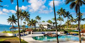 太平洋港南太平洋明珠Spa及高尔夫球场度假酒店的享有棕榈树度假村和游泳池的景色