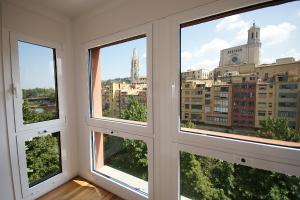 赫罗纳Flateli Canalejas的客房设有3扇窗户,享有城市美景。