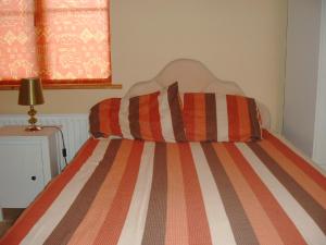 DoogortOcean View Doogort的卧室内的一张带条纹棉被的床