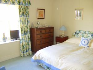 Shalbourne维斯科特住宿加早餐旅馆的一间卧室配有一张床、一个梳妆台和一扇窗户。