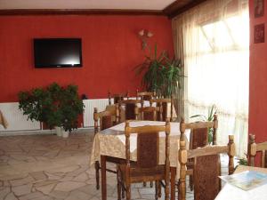 KharmanliOlympia的一间设有桌子的用餐室和红色墙壁上的电视